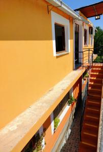 un edificio amarillo con escaleras y macetas en Hopedaje Felisa en Cafayate