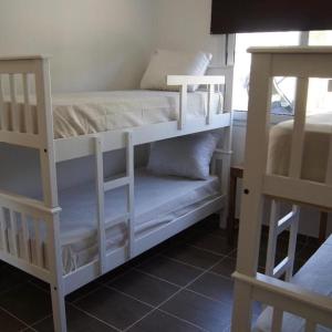 two white bunk beds in a room with a window at Cabaña La Verdicchio Urbanización Cristobal Lote 2 in Valle Grande