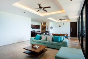 ein Wohnzimmer mit einem blauen Sofa und einem Tisch in der Unterkunft HERMOSO DEPATAMENTO EN PLAYA PROGRESO in Chicxulub