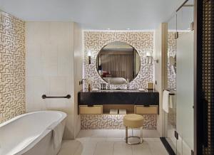 a bathroom with a tub and a round mirror at The Star Grand Hotel and Residences Sydney in Sydney