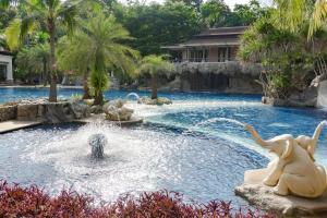 una piscina in un resort con due elefanti nell'acqua di Springfield Village Golf & Spa a Petchaburi