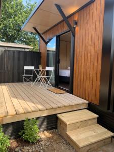 une maison dotée d'une terrasse en bois avec deux chaises dans l'établissement Snowman Cabins, à Ohakune