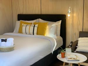 un letto con cuscini gialli e bianchi e un tavolo di Snowman Cabins a Ohakune