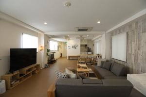 a living room with a couch and a flat screen tv at RIVER SUITES HIROSHIMA in Hiroshima