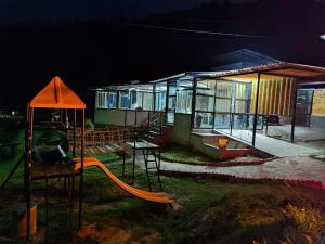 a playground with a slide in front of a building at El Rincón de Gabo in Nobsa