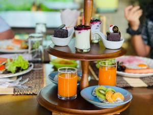a table topped with plates of food and orange juice at Chapulin Natural Resort in Chiang Mai