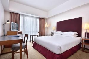 Habitación de hotel con cama grande y escritorio. en Hotel Capitol Kuala Lumpur en Kuala Lumpur