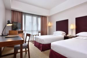 Habitación de hotel con 2 camas y escritorio en Hotel Capitol Kuala Lumpur en Kuala Lumpur