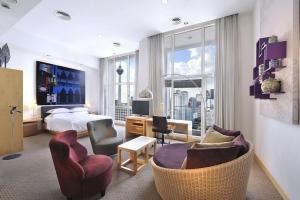 クアラルンプールにあるキャピトル ホテル クアラ ルンプールのベッドと椅子、ベッドルーム1室が備わります。