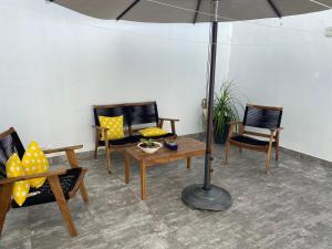 a patio with chairs and a table with an umbrella at Closetoairport in Cancún