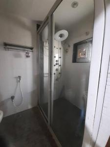 a bathroom with a shower and a glass door at Jubilee Hills Duplex Villa For Family Stay in Hyderabad