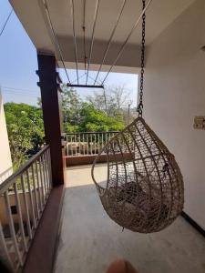 a hanging hammock on a porch with a balcony at Jubilee Hills Duplex Villa For Family Stay in Hyderabad