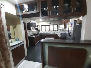 a large kitchen with wooden cabinets and a counter top at Jubilee Hills Duplex Villa For Family Stay in Hyderabad