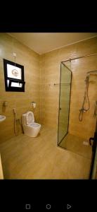 a bathroom with a toilet and a glass shower at Estrahet Al Haitham in Al Qal‘ah