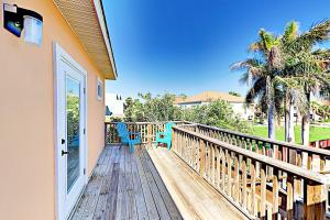 a deck with two chairs and a door at Acapulco Unit A in South Padre Island