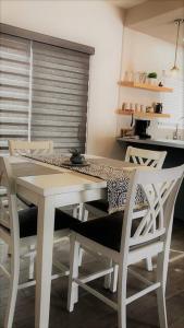 a kitchen with a white table and chairs at Lovely 1 Bedroom Apartment w/private Parking in Ensenada