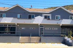 a blue house with a gate and a fence at Lovely 1 Bedroom Apartment w/private Parking in Ensenada