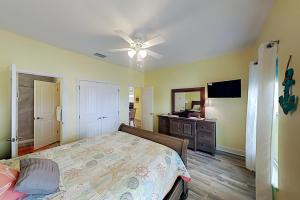 1 dormitorio con 1 cama y ventilador de techo en Flip Flop and Relax, en Port Aransas