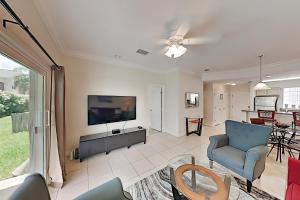 sala de estar con TV y sofá en Moon Dancer Condominiums, en South Padre Island