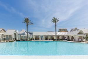 a large swimming pool with palm trees in front of a building at Turtle Ransas & Seaside Paradise in Port Aransas