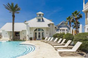 a row of lounge chairs next to a swimming pool at Turtle Ransas & Seaside Paradise in Port Aransas