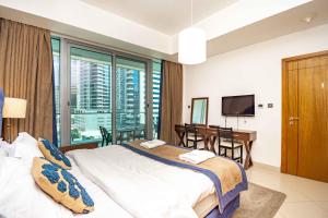 a bedroom with a bed and a desk and a television at Stylish and Sleek 1 Bed + Study near the JBR beach in Dubai