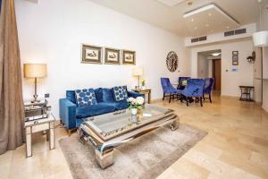 a living room with a blue couch and blue chairs at Stylish and Sleek 1 Bed + Study near the JBR beach in Dubai