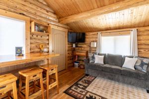 a living room with a couch and a bar in a log cabin at Hidden Haven Cabin in Columbia Falls