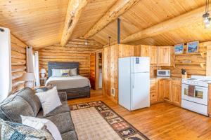 a living room with a bed and a refrigerator at Hidden Haven Cabin in Columbia Falls
