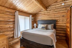 a bedroom with a bed in a log cabin at Hidden Haven Cabin in Columbia Falls
