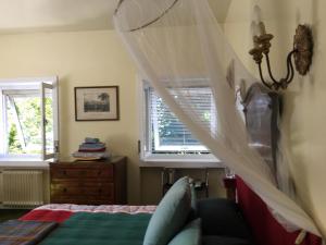 a bedroom with a canopy bed and a window at La Casa Blu di Monasteto in Tricesimo