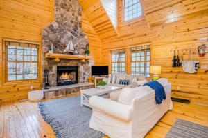 a living room with a stone fireplace in a log cabin at Kingfisher Cove Cabin 19 in Saugatuck