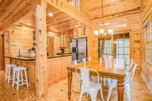 a dining room with a wooden table and white chairs at Kingfisher Cove Cabin 19 in Saugatuck