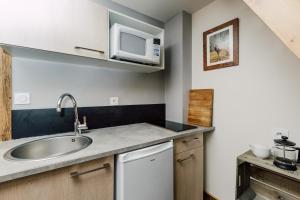 a kitchen with a sink and a microwave at Petit Lumina in Morzine