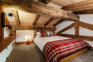 1 dormitorio con 1 cama en una habitación con techos de madera en Petit Lumina en Morzine