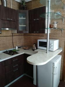 a kitchen with a counter top with a microwave at 2-x Apartments Center Wi-Fi около Площади in Chernihiv