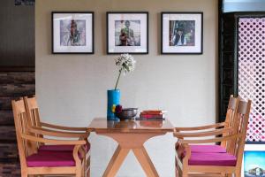 a wooden table with two chairs and a vase with flowers at Nadis - A handcrafted boutique hotel in Srinagar +20 photos