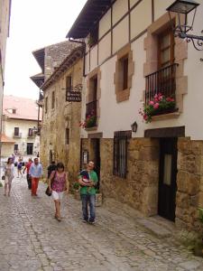 a group of people walking down a cobblestone street at Hospedaje Angelica in Santillana del Mar