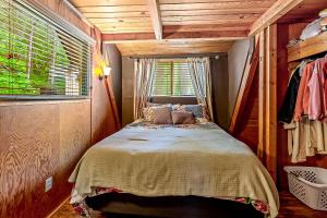ein kleines Schlafzimmer mit einem Bett und einem Fenster in der Unterkunft Kidd Island Bay Cabin Retreat in Coeur d'Alene