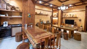 une cuisine avec une grande table et des chaises en bois dans l'établissement Alishan Hinoki B&B, à Alishan