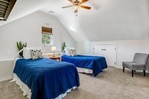 2 Betten in einem Zimmer mit blauer Bettwäsche und einem Stuhl in der Unterkunft Hummingbird Treehouse in Canyon Lake