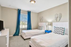 een slaapkamer met twee bedden, een tv en blauwe gordijnen bij Endless Magic in Kissimmee +42 foto's