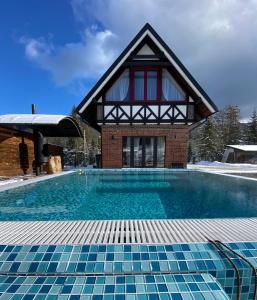 a house with a swimming pool in front of a building at Yozefstal in Myslovka