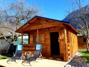 a cabin with two chairs and a table on a deck at SočaLand Glamping in Bovec