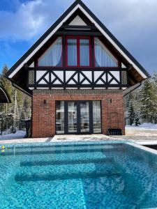 a house with a swimming pool in front of it at Yozefstal in Ludvikuvka