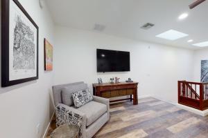 a living room with a chair and a tv at Menlo Magic in Tucson