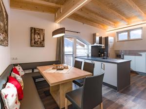 a small kitchen and dining room with a table and a kitchen at Dani's Ferienwohnung in Söll