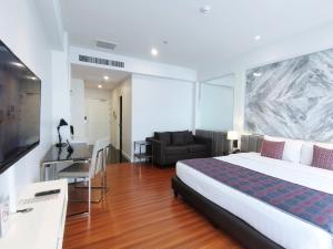 um quarto com uma cama grande e uma sala de estar em The Bless Hotel and Residence em Bangkok