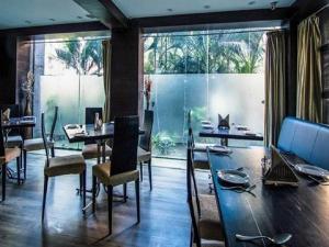 jadalnia ze stołem i krzesłami oraz dużym oknem w obiekcie The CORPORATE w mieście Kolkata