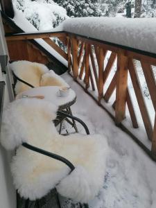 dwa krzesła pokryte śniegiem na balkonie w obiekcie Willa Mitia w Zakopanem